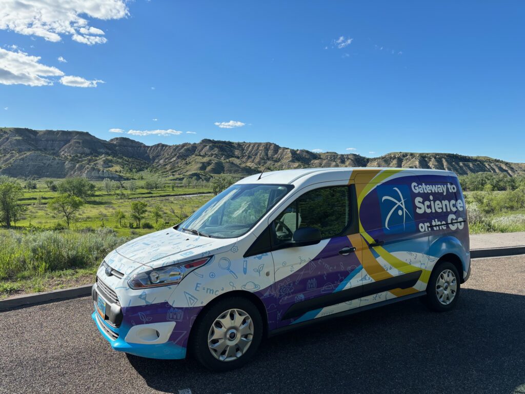 picture of the gateway to science on the go van in front of hilly scenery